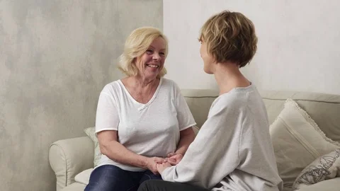 Happy elderly mother holding hands his adult daughter, talk and hugs her Stock Footage 82281430