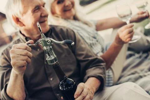 Happy elderly pair going to drink wine Stock Photos