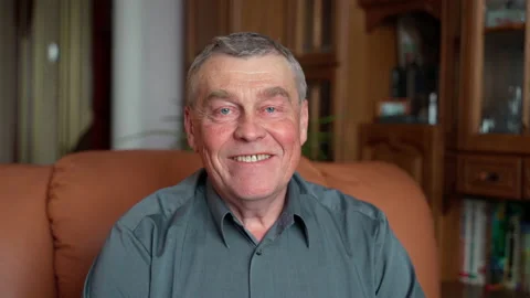 Happy elderly senior gray-haired 60s man smiling face healthy teeth sit on sofa Video stock 152709261