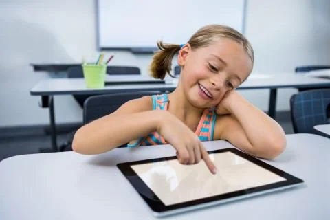 Happy elementary girl using digital tablet in classroom 스톡 사진