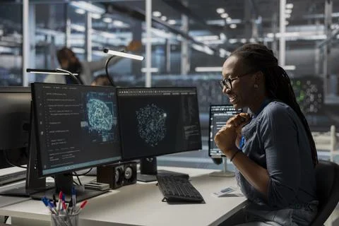 Happy engineer in data center using AI powered tech to run simulations Stock Photos