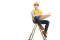 The happy engineer with a paper sitting on the ladder on the white background Photo