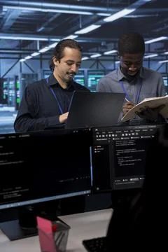 Happy engineers checking for signs of imminent failure in data center Stock Photos