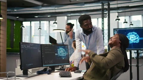 Happy engineers enjoying funny conversation at desk while using AI Stock Footage 313017146