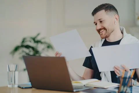 Happy entrepreneur looking at documents while working at home office Stock Photos