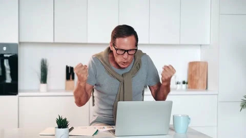 Happy excited old elderly man winner excited by reading good news looking at Stock Footage 219480593