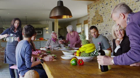 Happy extended family group sit down to enjoy a meal together at home Stock Footage