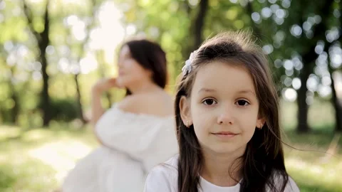 Happy face of a child in the rays of the sun. Mom and daughter Stock Footage 263307482