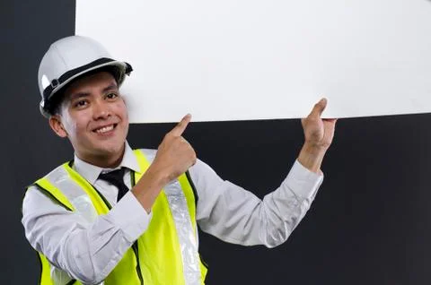Happy face young engineer or manager with white safety helmet holding white b Stock-Fotos