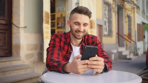 Happy face young man uses phone sitting in cafe smile feel happy blurred Stock Footage 92070911