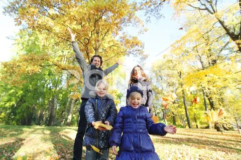 Happy family in autumn park Stock Photos