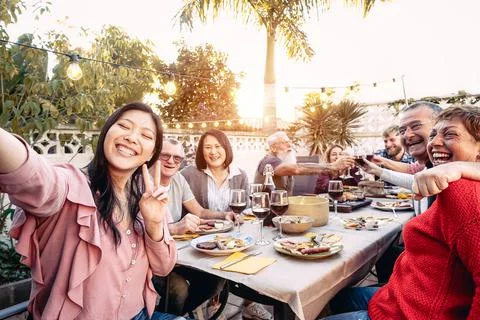 Happy family cheering and toasting with red wine glasses at dinner outdoor Stock Photos