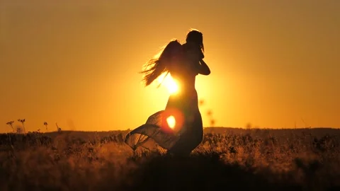Happy family child and mother playing together at sunset silhouette. people in Stock Footage