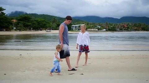 Happy family with children walks along the beach Stock Footage
