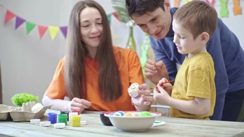 Happy family is coloring Easter eggs in a decorated room and having fun Stock Footage 196226620