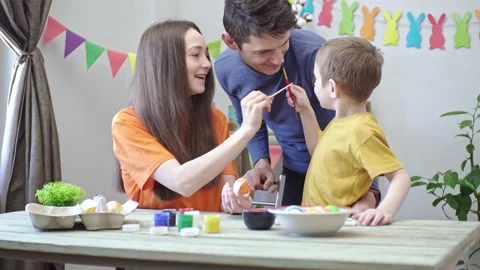 Happy family is coloring Easter eggs in a decorated room and having fun Stock Footage 196226958