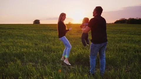 Happy family couple playing with the baby son in a catch-up. Dad with a boy in Stock Footage