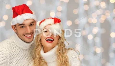 Happy family couple in sweaters and santa hats Stock Photos