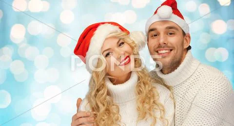 Happy family couple in sweaters and santa hats Stock Photos