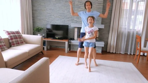 A happy family. Dad and daughter having fun in a clean house. A man is dancing  Stock Footage