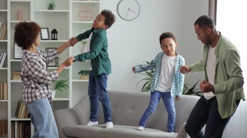 Happy family dancing having fun together with little sons in modern living ro Stock Footage 253587920