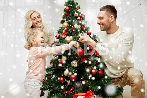 Happy family decorating christmas tree at home Stock Photos