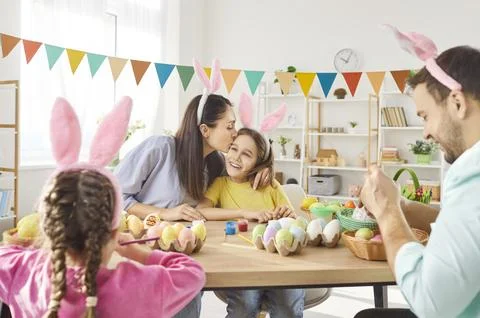 Happy family decorating for Easter, doing eggs ornaments on spring holiday Stock Photos