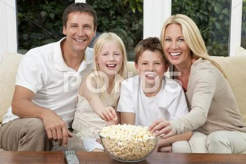 Happy family eating popcorn watching television Stock-Fotos