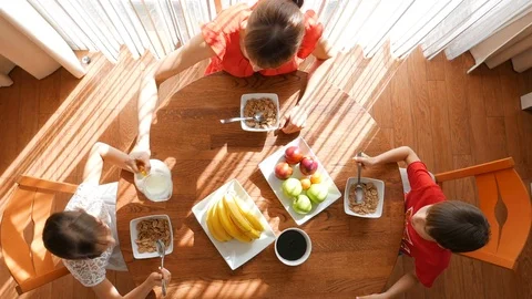 A happy family eats at the table. Breakfast. Mother and her children have breakf Stock Footage 77703611