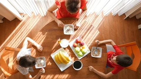 A happy family eats at the table. Breakfast. Mother and her children have breakf Stock Footage