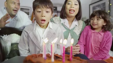 Happy family enjoying a Birthday celebration for young son Stock Footage