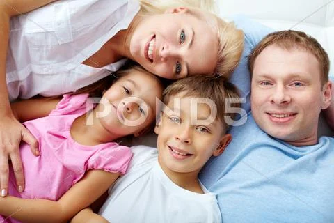 Happy family of four resting at home Stock Photos
