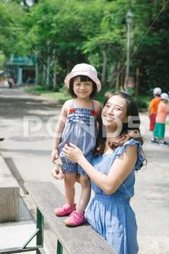 Happy family having fun with animals safari park on warm summer day. Stock Photos