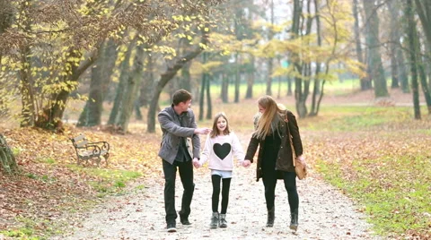 Happy family holding hands and walking in park Stock Footage 59554220