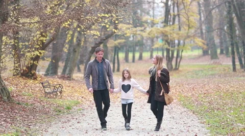 Happy family holding hands and walking in park Stock Footage 59554227