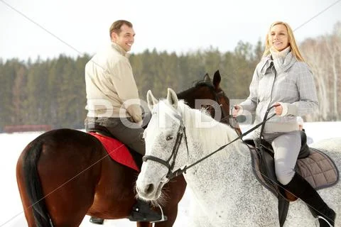 Happy family horseback riding in winter Stock Photos