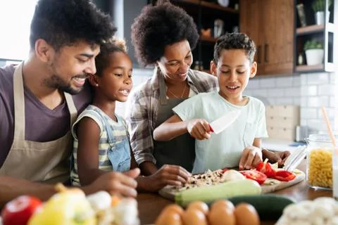 Happy family in the kitchen having fun and cooking together. Healthy food at Foto stock