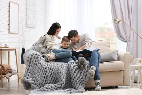 Happy family with little son reading books at home. Winter vacation Stock Photos
