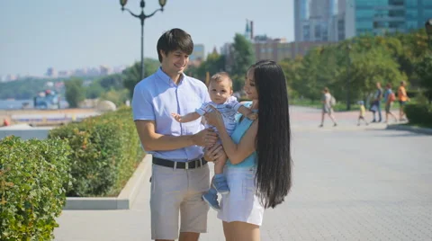 Happy family looking at the camera while standing on the alley Stock Footage 68751763