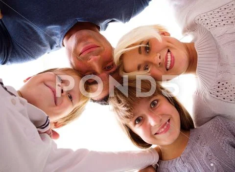 Happy family looking down at camera Stock-Fotos