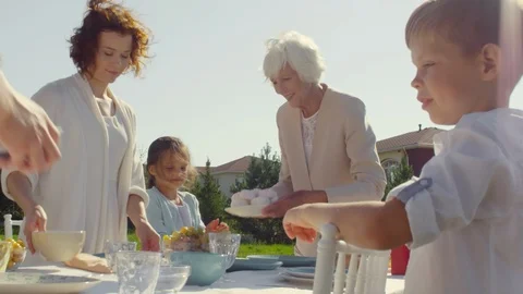Happy Family Preparing Table for Holiday Dinner Outdoors Stock Footage