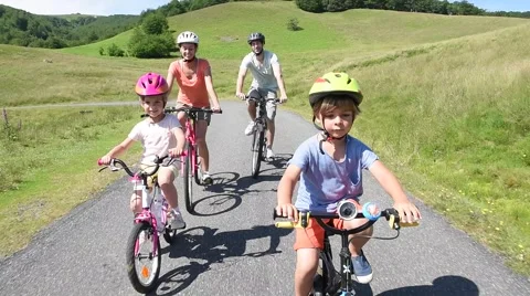 Happy family riding bikes in mountain road Stock Footage