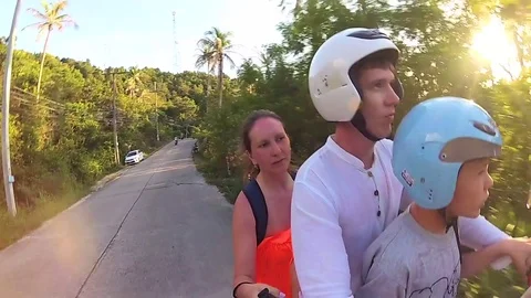 Happy family riding a motorcycle in the tropics. A bright Sunny day. PHANGAN Stock Footage