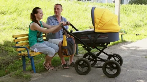 happy family rocking baby in stroller