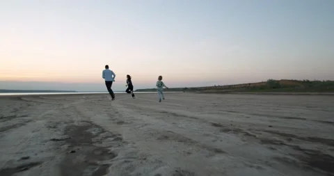 Happy family run together at sunset. A small child, daughter and father have fun Stock Footage