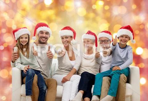 Happy family in santa hats showing thumbs up Stock Photos