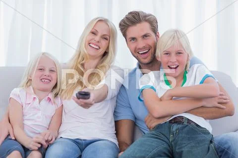 Happy family sitting on couch Stock Photos