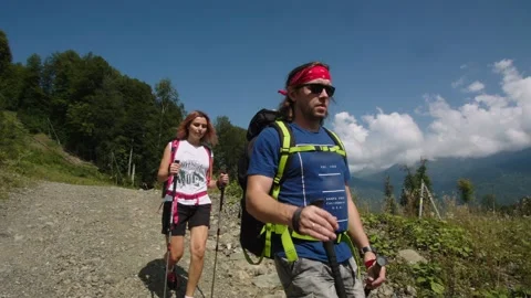 Happy family with ski poles going down the stone road against the blue sky Stock Footage 208879341