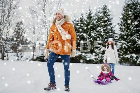 Happy family with sled walking in winter outdoors Stock Photos