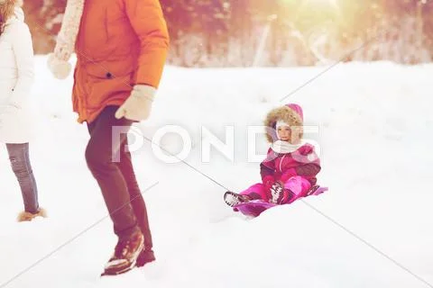 Happy family with sled walking in winter forest Stock Photos
